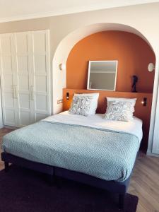a bedroom with a large bed with an orange headboard at So Guest, suite supérieure hypercentre terrasse in Reims