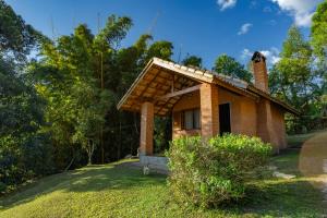 a small brick house with a chimney on a hill at Pousada Lua Bonita in São Bento do Sapucaí