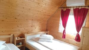 a bedroom with a bed in a log cabin at Cabana Colt de Rai in Ocna Şugatag
