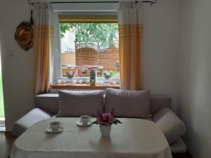 a living room with a table and a couch and a window at Domek pod Orzechem in Kudowa-Zdrój