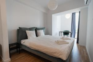 una camera da letto con un letto grande con lenzuola bianche di Lagoon Park Apartments with Beach View a Bucarest
