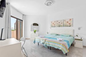a white bedroom with a bed and a desk at Atlantic Sky Panorama in Costa Del Silencio +40 photos