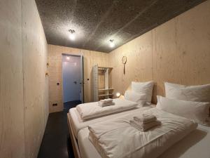 two white beds in a room with at MOMAI 1891- moderne Ferienwohnung in Maikammer