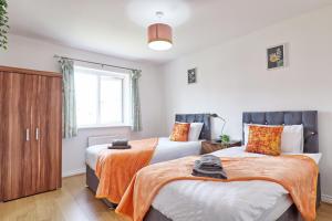 a bedroom with two beds and a window at ESSEX Basildon 4 bedroom house 2 half bath in Basildon