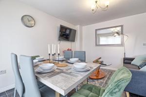 a dining room with a table and a couch at ESSEX Basildon 4 bedroom house 2 half bath in Basildon