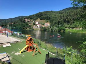 a river with a playground with a slide and people in the water at Casa nel bosco in Osiglia