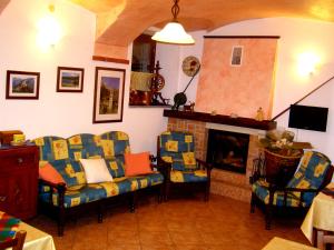 sala de estar con sillas y chimenea en L'Antico Borgo Rooms Rental, en Caprie
