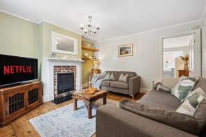 ein Wohnzimmer mit Couch und Kamin in der Unterkunft 2-Bedroom Stylish & Gorgeous, Cosy Westgate Cottage Retreat, Central Winchester, Free On-Street Parking Permit, with Garden, Close to Cathedral - Sleeps 6, Pets are Welcome - by Blue Puffin Stays in Winchester