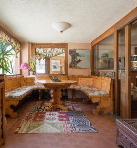 ein Esszimmer mit Bänken, einem Tisch und einem Tisch in der Unterkunft Hotel Da Compagnoni in Breuil-Cervinia