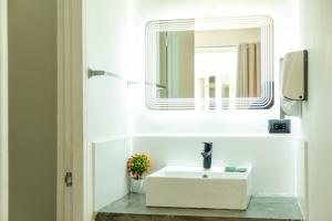 パナマシティにあるHotel Baluarte Boutique Panamaの白い洗面台と鏡のあるバスルーム +27枚の写真