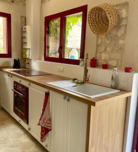 a kitchen with a sink and a counter top at Maison chaleureuse- cheminée, nature et sport ! in Muids
