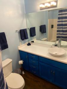 a bathroom with a sink and a toilet and a mirror at The Hilltop Cabin Retreat in Bass Lake Heights in Oakhurst +6 photos