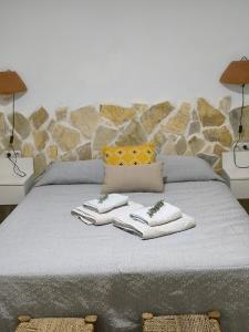 a bed with two lamps and towels on it at Casas Rurales Villa Sargento in Níjar +18 photos