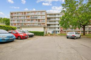 a parking lot with cars parked in front of a building at Duplex apartment downtown with parking in Cergy