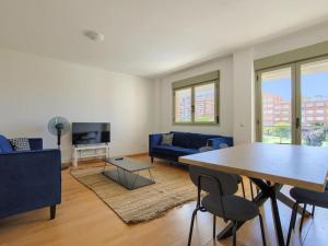 a living room with a table and a blue couch at Dobo Getafe Bercial in Getafe
