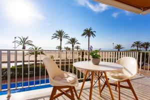 a balcony with a table and chairs and the beach at Cullera Horizon Apartment in Cullera