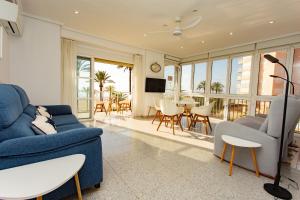 a living room with a blue couch and chairs at Cullera Horizon Apartment in Cullera