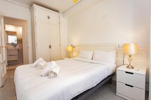 a white bedroom with a large white bed and two lamps at Cullera Horizon Apartment in Cullera +40 photos