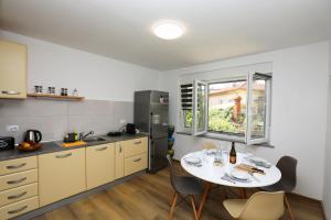 a kitchen with a table with chairs and a window at Apartment Ondina in Rijeka