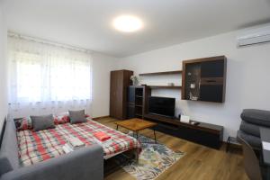 a living room with a bed and a tv at Apartment Ondina in Rijeka
