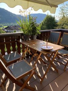 a wooden table and chairs on a deck at Ferienwohnung im Landhausstil in Missen-Wilhams