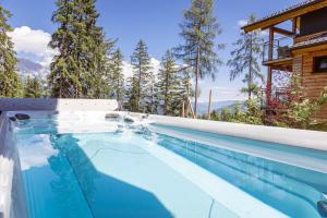 a swimming pool in front of a house at Alpenchalets Reiteralm by ALPS RESORTS in Schladming