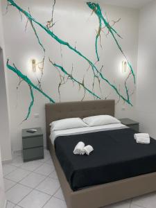 a bedroom with a bed with branches on the wall at Maison Museo in Naples