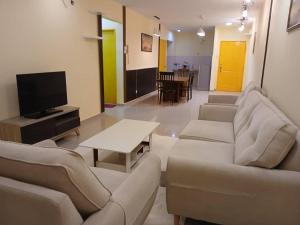 a living room with couches and a tv and a table at Monkey Mansion in Kuala Lumpur