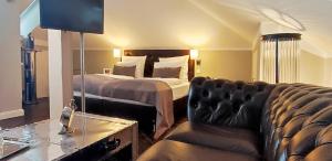 a bedroom with a bed and a couch at Villahotel Rheinblick in Cologne