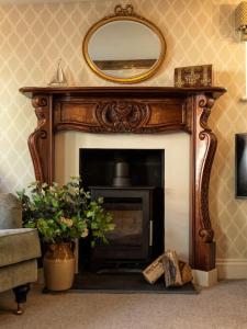 a living room with a fireplace with a mirror at Quaint 18th Century Cottage in Lymington in Lymington