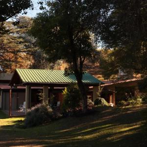ein Haus mit einem grünen Dach und einem Baum in der Unterkunft Casa en Ascochinga privado. Sierras de Córdoba in Ascochinga