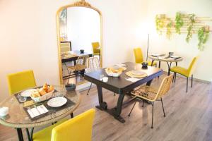 a dining room with two tables and chairs and a mirror at Le Parc du Château in Hermonville