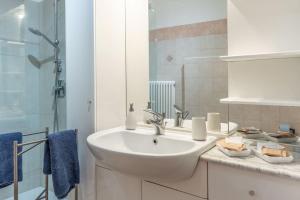 a white bathroom with a sink and a shower at HISTORIC CENTER VIEW - 2 minutes from the Castle & Private Free Parking- Fast Wifi Historical Palace in Trento