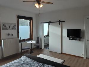 a living room with a bed and a flat screen tv at chantal&thierry in Éghezée