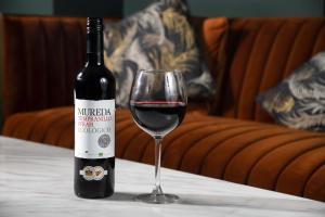 a bottle of red wine sitting next to a glass at The Kirkhouse Inn in Strathblane