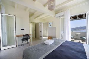 a bedroom with a bed and a view of the ocean at Ariti's Villas 1 - Naxos in Naxos Chora