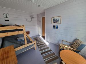 a small room with a bunk bed and a chair at Helligskogen Fjellstue med sauna in Helligskogen