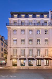 a tall white building with windows and a balcony at Hotel Moon & Sun Lisboa in Lisbon