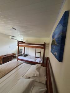 a bedroom with two bunk beds and a painting on the wall at Pousada Lua Cheia in Ilha do Mel