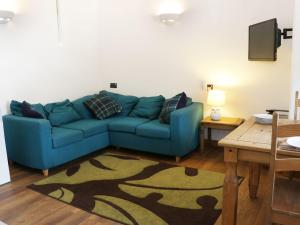 a living room with a blue couch and a table at Woodside Cottage in Newtown