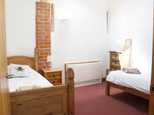 a bedroom with two beds and a dresser at Woodside Cottage in Newtown