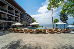 a row of chairs and umbrellas next to a beach at Dusit Buncha Koh Tao by Riya Group in Ko Tao