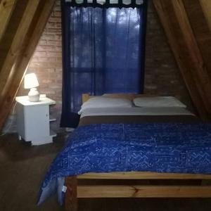 ein Schlafzimmer mit einem blauen Bett und einem Fenster in der Unterkunft Cabañas Alpinas San Pedro in San Pedro