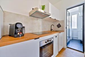 eine kleine Küche mit Spüle und Herd in der Unterkunft Le Cœur des Antiquaires - 5 min de Paris in Saint-Ouen