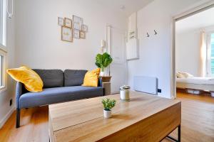 ein Wohnzimmer mit einer Couch und einem Couchtisch in der Unterkunft Le Cœur des Antiquaires - 5 min de Paris in Saint-Ouen