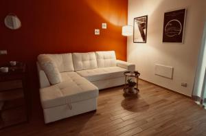 a living room with a white couch and a chair at A casa di Sara in Ostia Antica