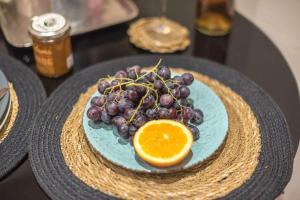 a plate of grapes and an orange on a table at Dion Luxury Suite in Kolonaki with jacuzzi in Athens
