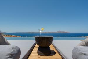 a table on a balcony with a view of the water at ARion Aesthesis Superior Villa Heated Pool in Kókkinon Khoríon