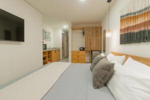 a bedroom with a large white bed with pillows at Cozy apartment with pool in Bacalar Center in Bacalar