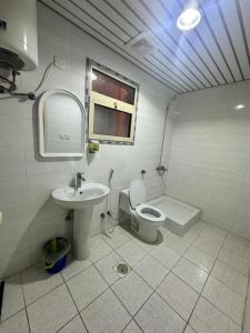 a bathroom with a toilet and a sink at نجوم السعد 7 in Al Masfalah